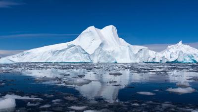 Iceberg in Antarctica, blue water, white ice, sunny day.