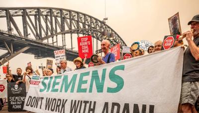Siemens and Adani logos side-by-side, with a blue background.