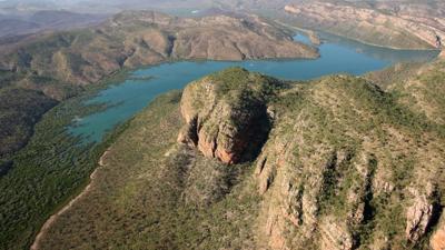 Kimberley estuary, aerial view. Mudflats, winding river, mangrove vegetation, blue water, and sky.