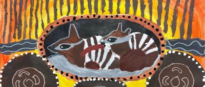 Numbat, Olivia, in a grassy field, looking towards the camera.