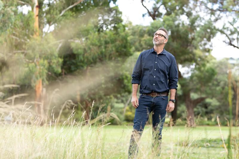 Paul Sinclair, ACF Director of Campaigns, standing in long grass and looking up into the canopy