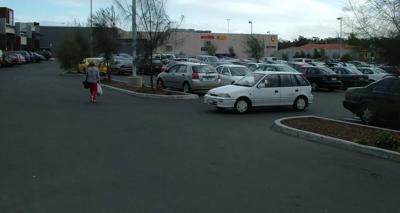 Header image: Cars driving on a road, blue sky, and green trees.