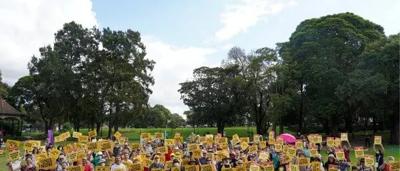 Picnic scene, diverse group, outdoor setting, climate action banner, sunny day.