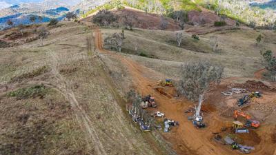 20230529 Aerial Photo of Deforestation in Nandewar Armidale-8 Wide shot of land clearing with machinery trucks diggers bulldozers and excavators with hillside and devastation behind it