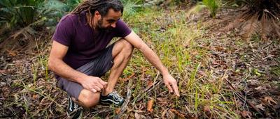 Man in a suit, standing, holding a microphone, speaking at a podium.