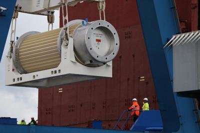 Nuclear waste cask, cylindrical metal container, outdoors.