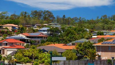 Solar panels on rooftops, blue sky, sunny day.