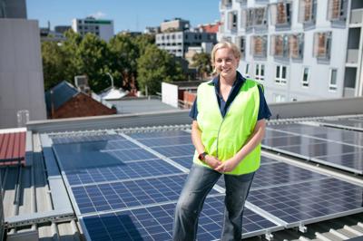 Solar panels on a roof, blue sky background.