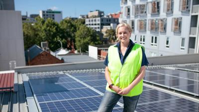 Solar panels on a roof, blue sky background.