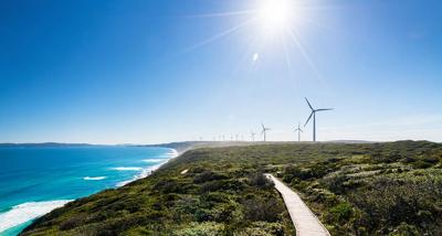Wind turbines in a field, blue sky, header image.