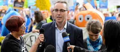 Header image: Person in interview, microphone, blurred background, text overlay.