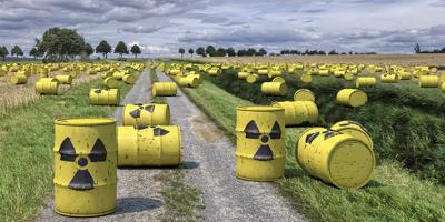 Nuclear waste containers stacked, warning symbols visible.