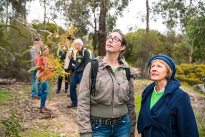 Large group of people, outdoor event, banner, stage, sunny day.