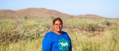 Two people smiling, standing outdoors, sunny day, Karratha, Western Australia.