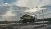 Coal truck on road, dust cloud, industrial landscape, blue sky.