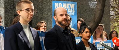 Man speaking at a podium, ACF logo, crowd in background, outdoor setting.