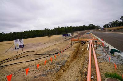 Green hill with trees, blue sky, and a few clouds.