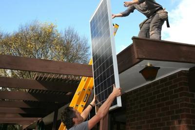 Solar panel installation on a rooftop, showing panels, roof structure, and sunlight.