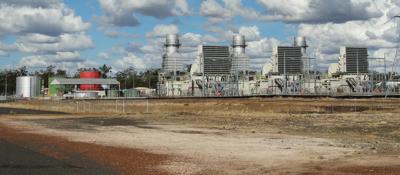 Gas plant with smokestacks against a blue sky.