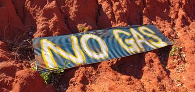 No Gas sign, white text on blue, with a green tree silhouette.