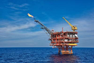 Woman in a white dress, standing in a field of yellow flowers, sunny day.