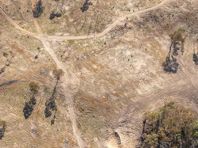 Drone shot of red-hued mountain range, possibly a desert landscape.