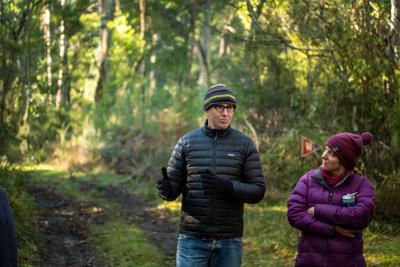 Two people hiking, one speaking. Mountain backdrop.