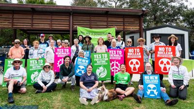 Picnic scene, diverse group, outdoor setting, food, blankets, trees, people smiling.