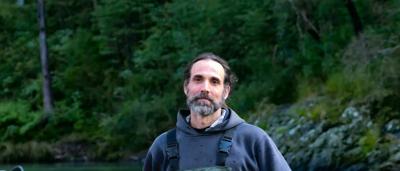 Portrait of Dr. Gilad Bino in a creek, wearing glasses, smiling.