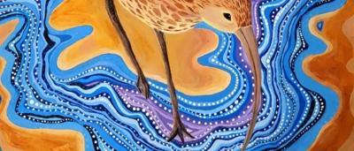 Woman in white shirt, holding a sign, standing in front of a building.