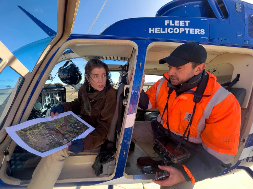 ACF investigator Kim Garratt and campaigner Nat Pelle reviewing a map inside a helicopter before flying over land clearing in the Nandewar Range
