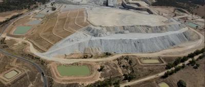 Mine entrance, dark tunnel, wooden supports, sunlight at opening.