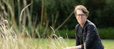 Woman, Basha Stasak, smiling outdoors, nature background.