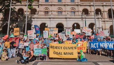 Protest banner, crowd, Palmer, Australian flag, sky.