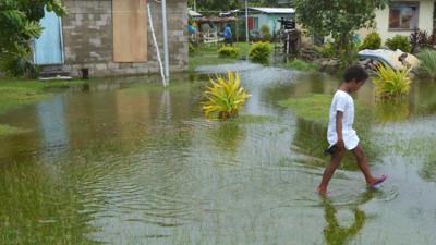 Fiji COP26 header image: Tropical island, palm trees, ocean, text overlay.