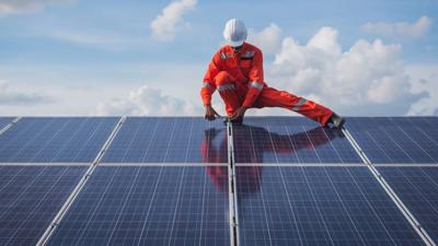 Solar panels on a rooftop, blue sky background.