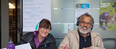 Group of people marching, holding signs, protest.