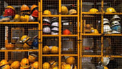 Close-up of several yellow and white construction helmets.