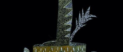 A numbat, an Australian marsupial, standing on a log in a forest setting.