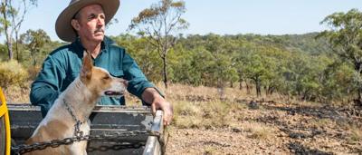 Farmer Bruce Currie in Jericho, QLD, standing in a field, smiling.