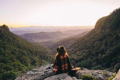 Lamington Mountains sunset. Orange and purple sky over green hills.