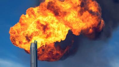 Gas flare burning brightly against a dark sky.