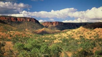South Kimberley landscape. Red earth, green vegetation, blue sky, distant hills.