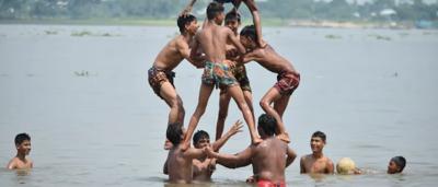 Boys in Bangladesh, playing in water, sunny day.