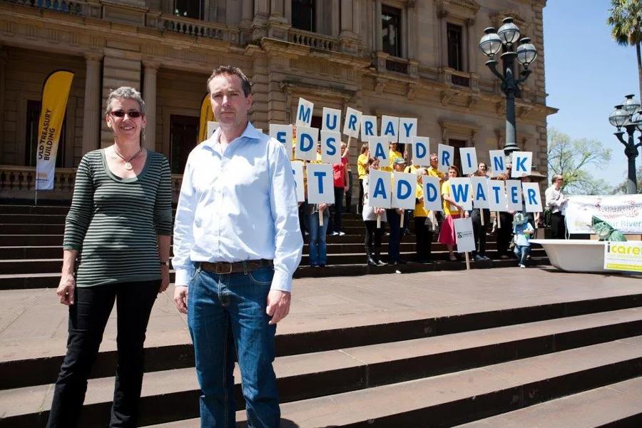 Paul Sinclair and Juliet Le Fevre with ACF and Environment Victoria volunteers holding a 'Murray Needs a Drink — Just Add Water' sign on the steps of Victorian Parliament
