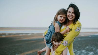 People, Liz, and kids smiling outdoors.