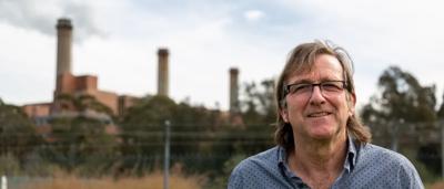 Man in a suit, smiling, headshot, professional portrait.
