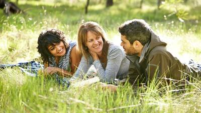 Woman smiling, headshot, outdoors, natural light, professional attire.