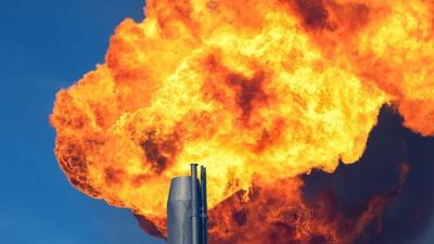 Gas flare emitting flames into the night sky.