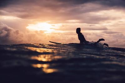 Surfer on wave, blue ocean, sunny day, people silhouette.